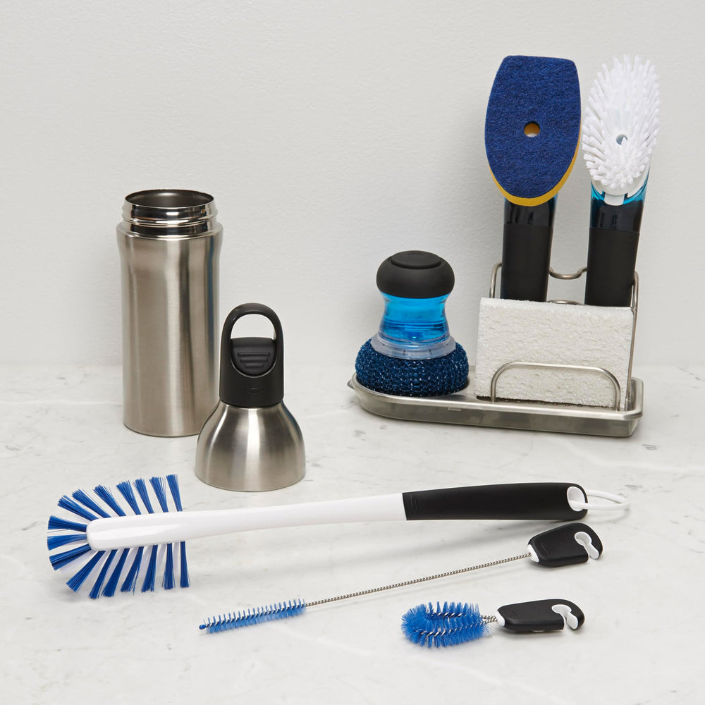 OXO Good Grips en uso limpiando el interior de una botella de acero inoxidable