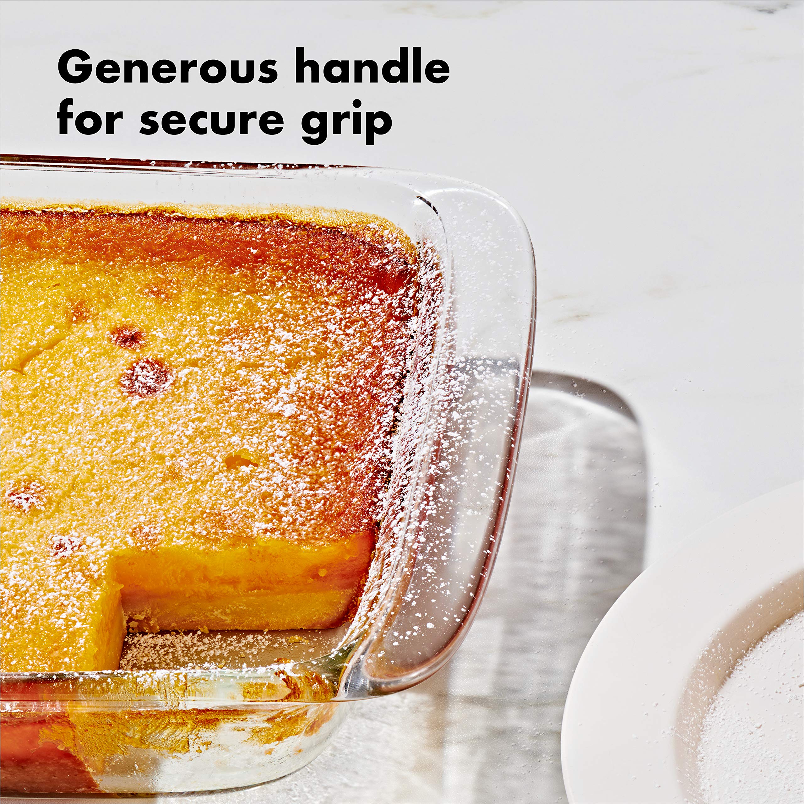 OXO hands lifting dish from oven using wide handles for secure grip