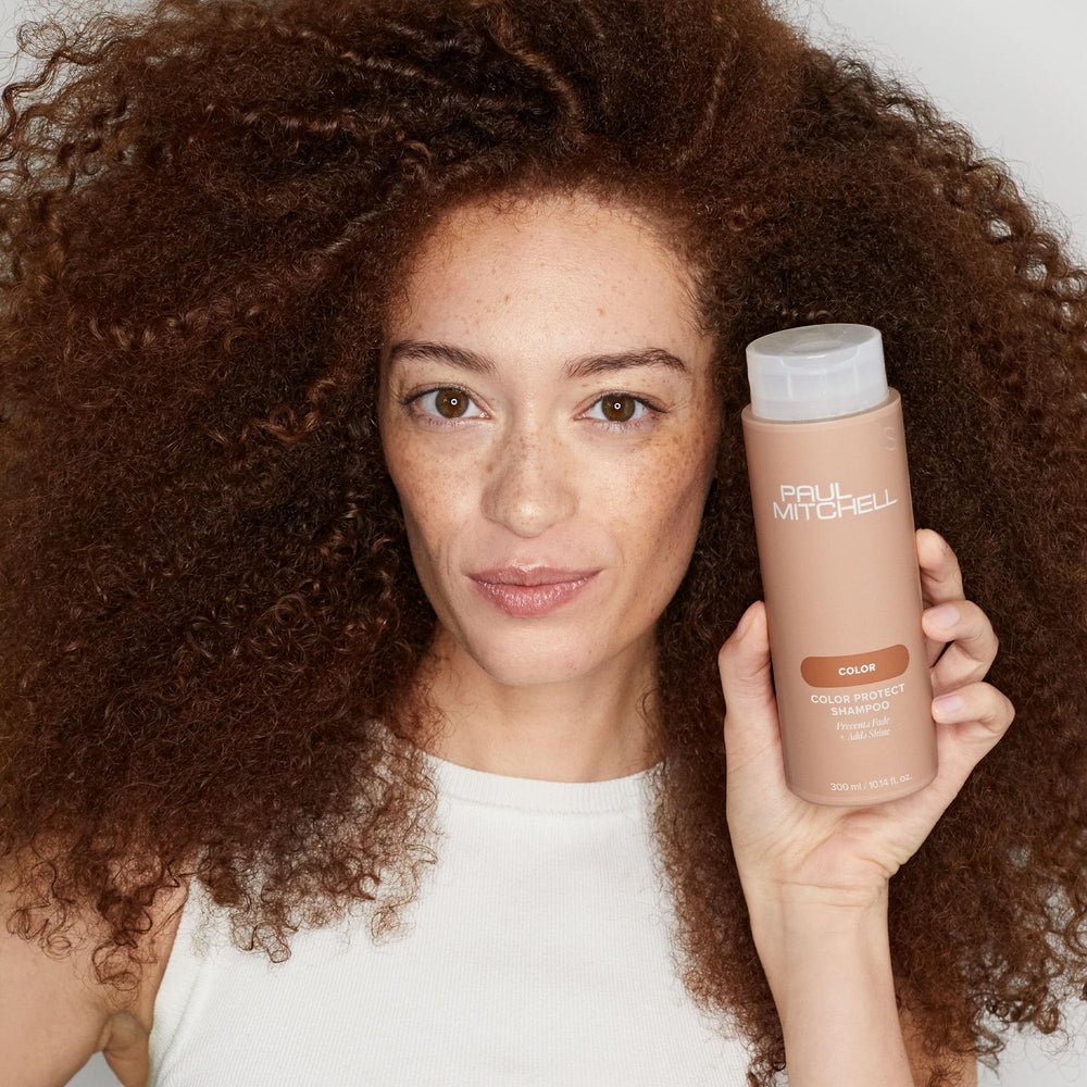 Paul Mitchell 16.9 fl oz bottle beside common objects for scale and value