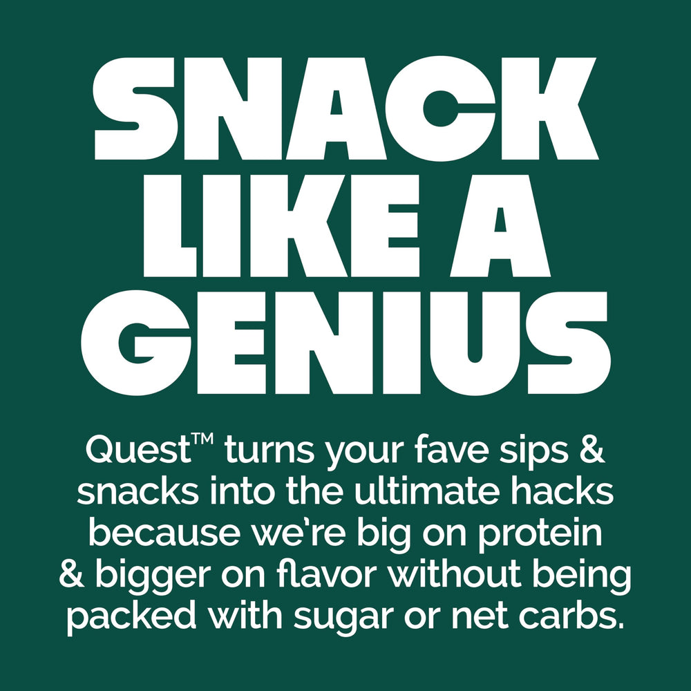 Quest barra junto a una toalla y pesas en gimnasio, snack post-entreno