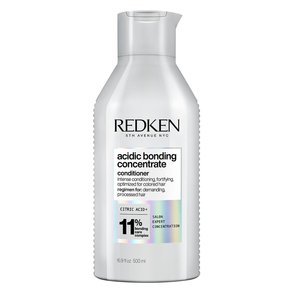 Redken bote frontal mostrando etiqueta y beneficio de reparación