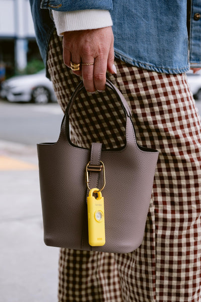 She’s Birdie clipped to a bag emphasizing quick access and hands-free security