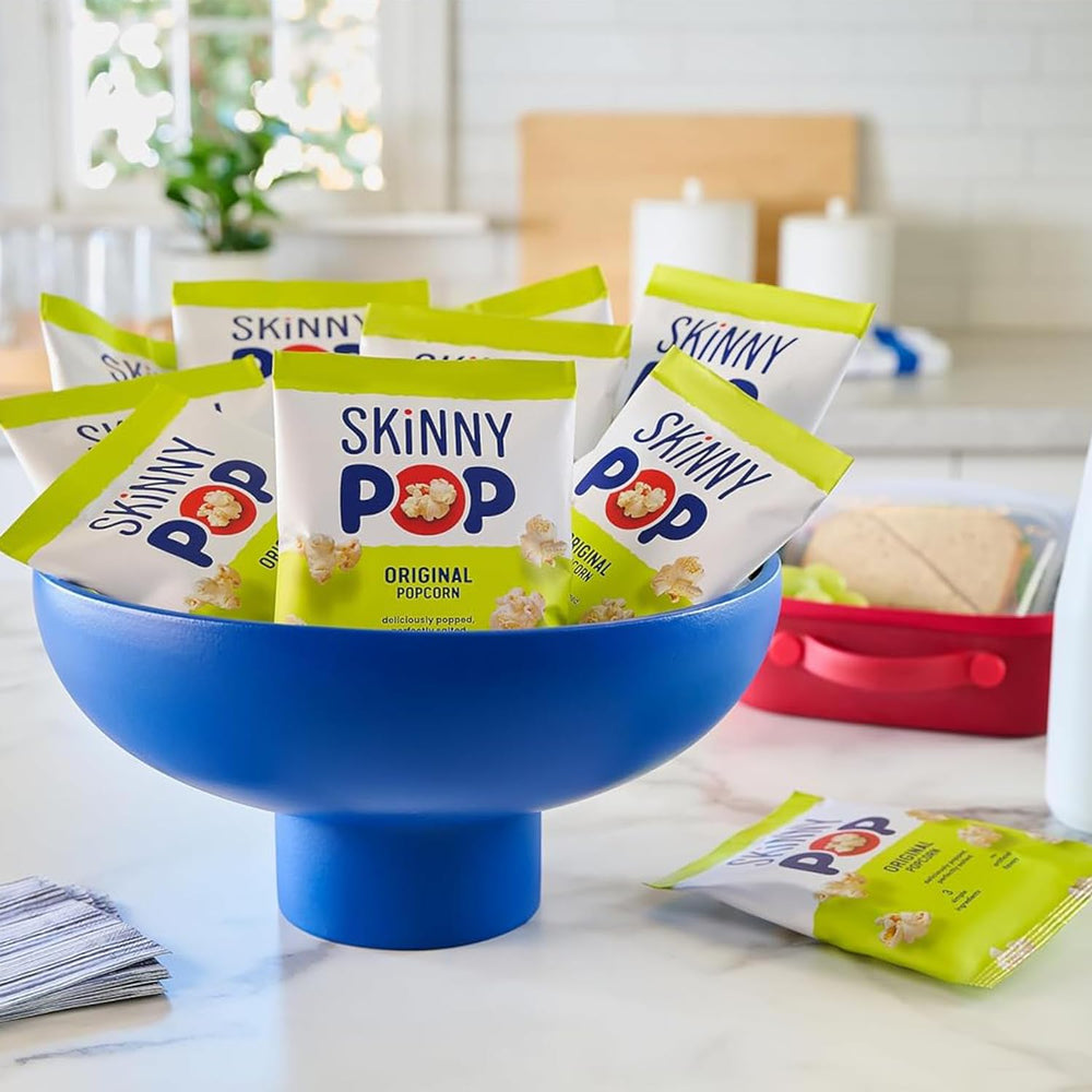 hand holding a SkinnyPop 0.5 oz bag to show compact portion size and on-the-go convenience