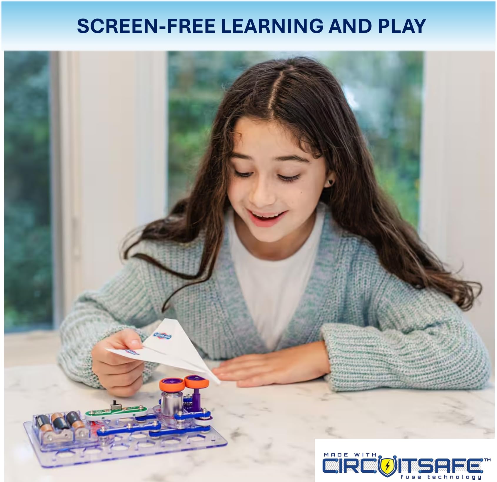 Snap Circuits flight deck montaje en manos de niño, fomenta confianza práctica