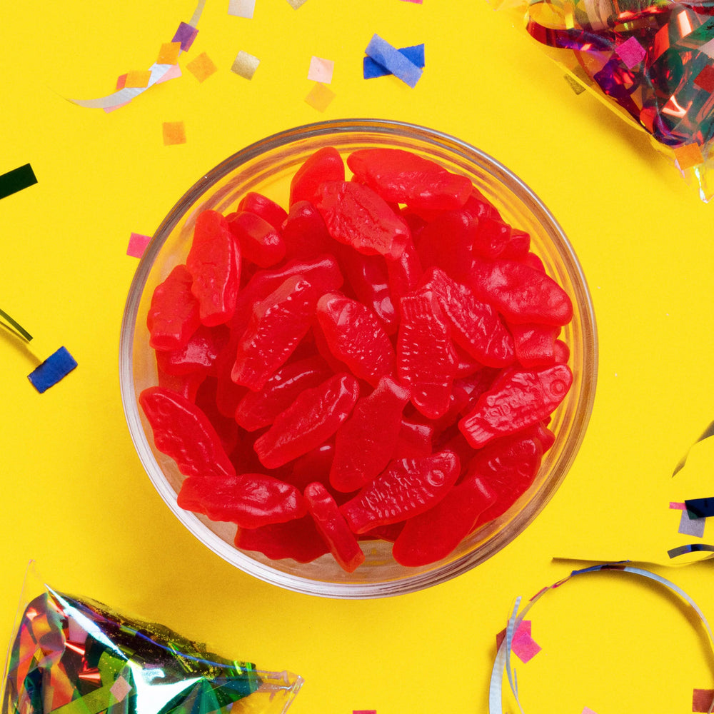 Escena de noche de cine en casa con Sour Patch Kids y SWEDISH FISH como snack