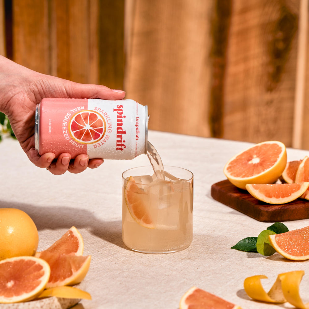 Comparación de tamaño de la lata Spindrift pomelo sostenida en mano