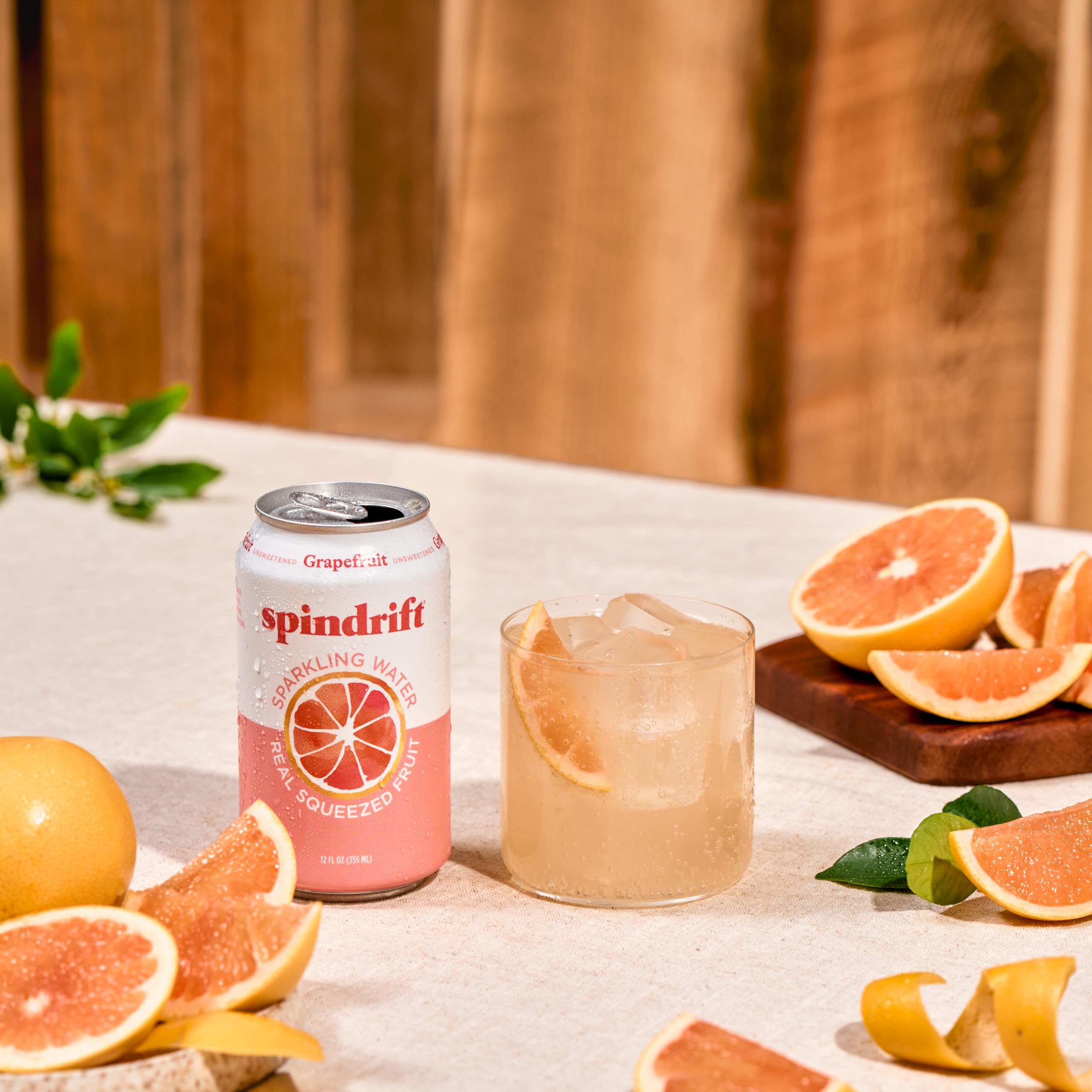 Pomelos frescos junto a una lata Spindrift resaltando jugo real