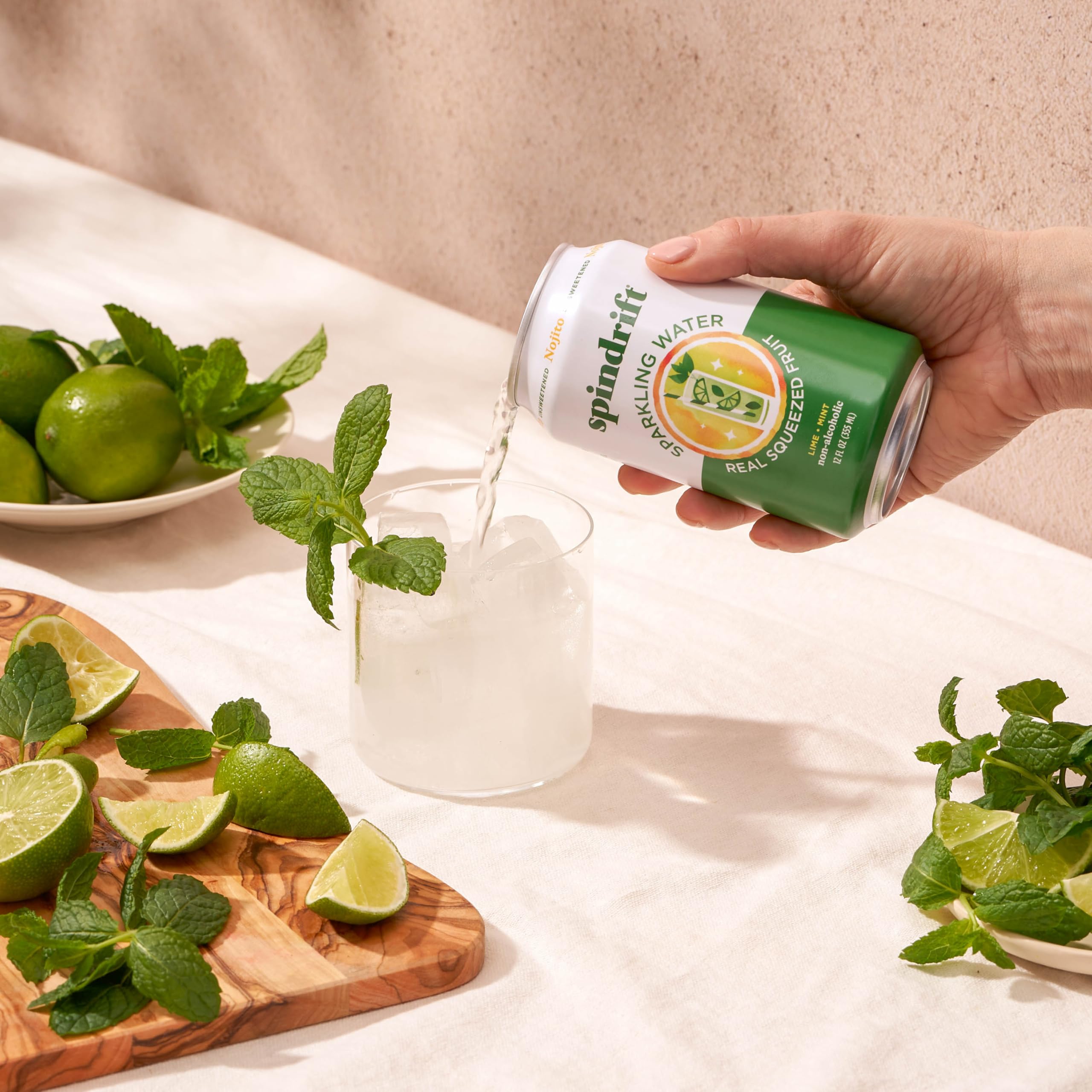 Comparación de tamaño de lata Spindrift Nojito con mano para escala