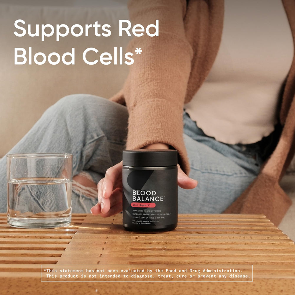 Persona tomando Sports Research Blood Balance con un vaso de agua