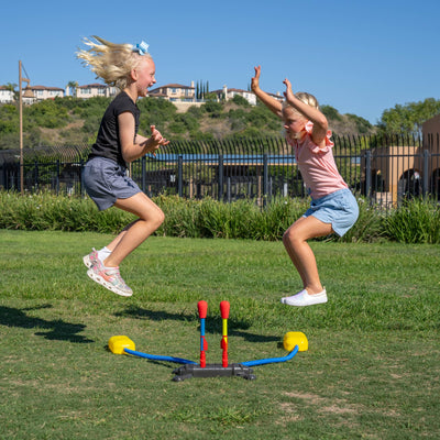 Group of kids using Stomp Rocket in backyard showing cooperative play and outdoor STEM learning