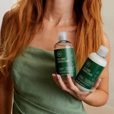 Tea Tree botella junto a objetos para comparar tamaño y uso