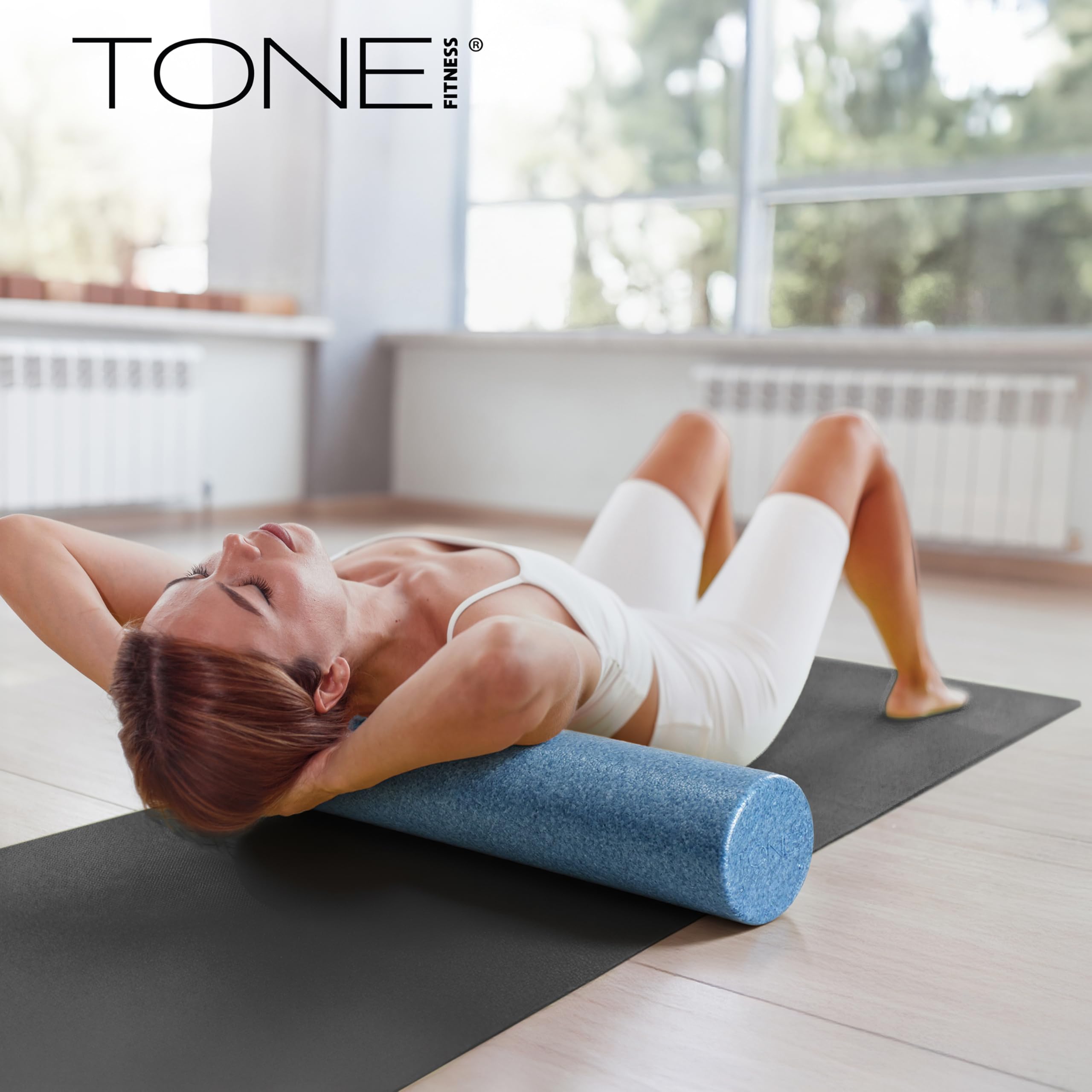 Tone Fitness roller next to dumbbells showing post-workout recovery pairing benefit