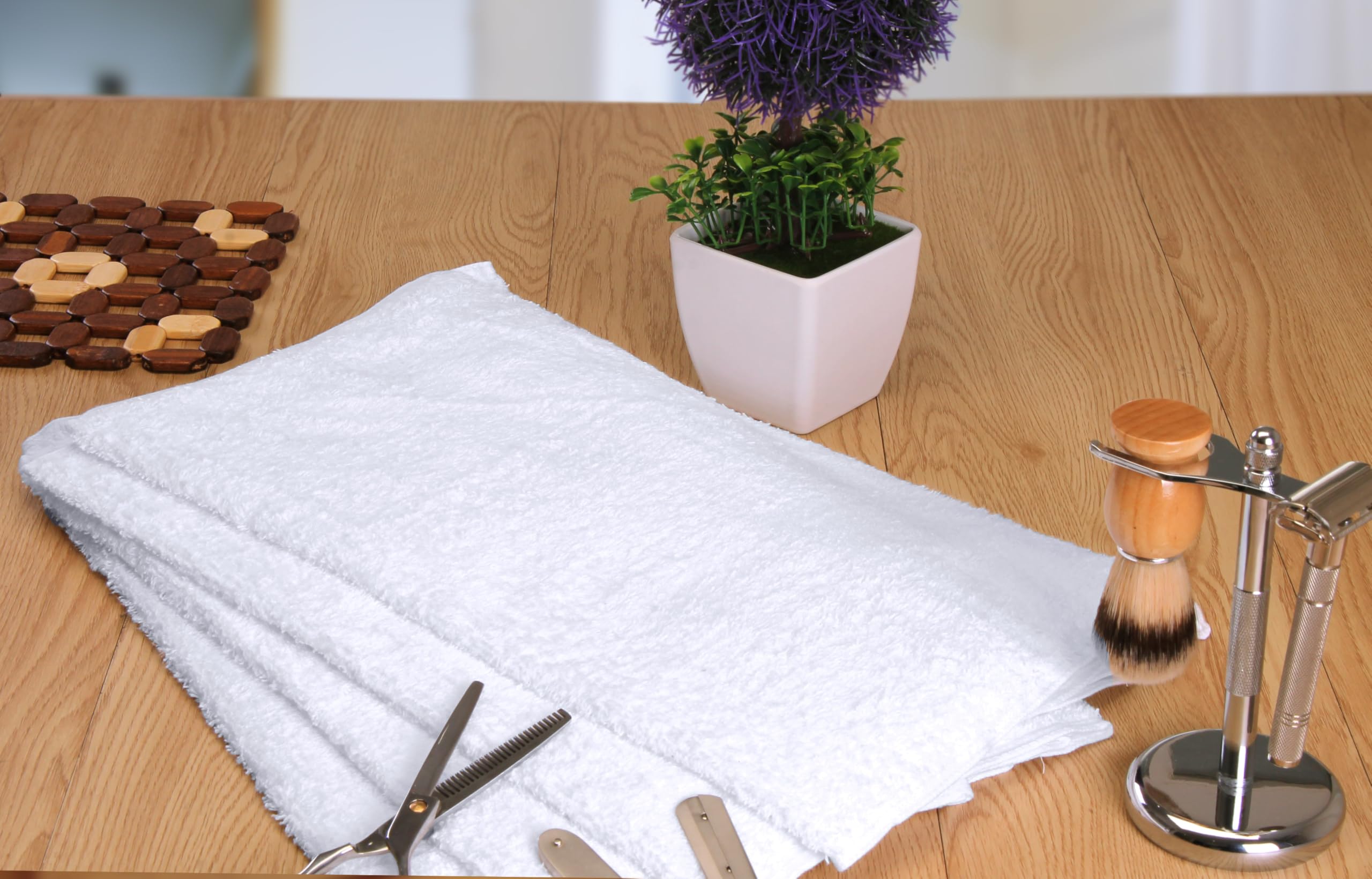 Utopia Towels comparación de tamaño junto a una mano mostrando 16x27 pulgadas