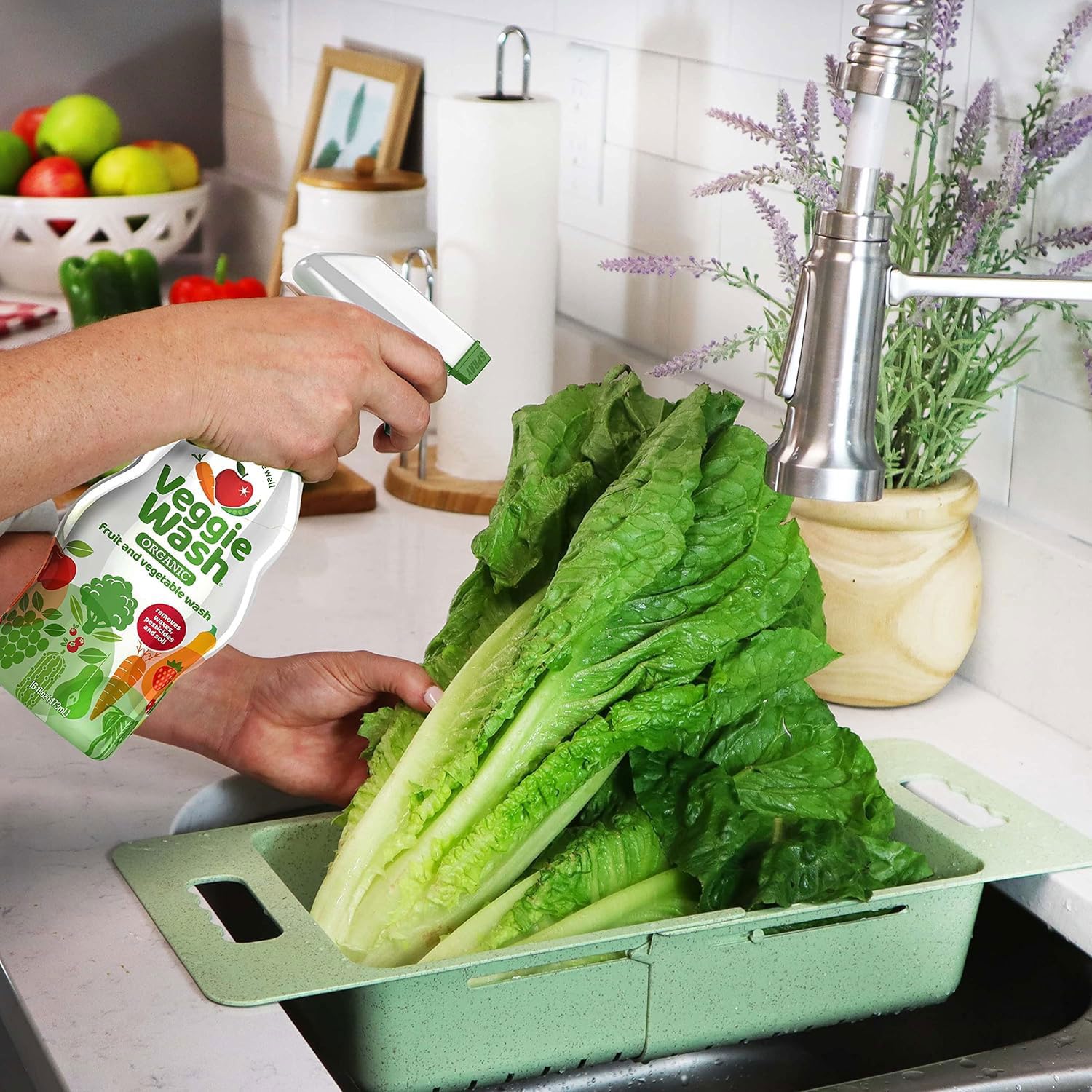 Veggie Wash junto a una mano y fruta para comparar tamaño del frasco práctico