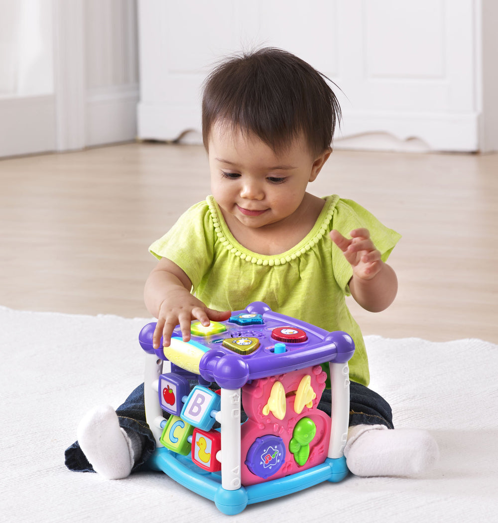 VTech cubo en uso con bebé jugando, promoviendo motricidad fina y curiosidad
