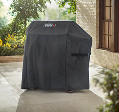 Weber cover on grill in backyard showing weather protection benefit
