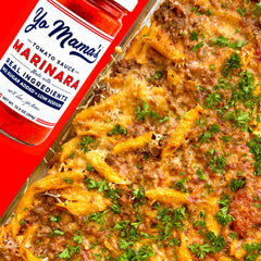 Frasco Yo Mama’s Foods junto a mano para comparar tamaño y porción