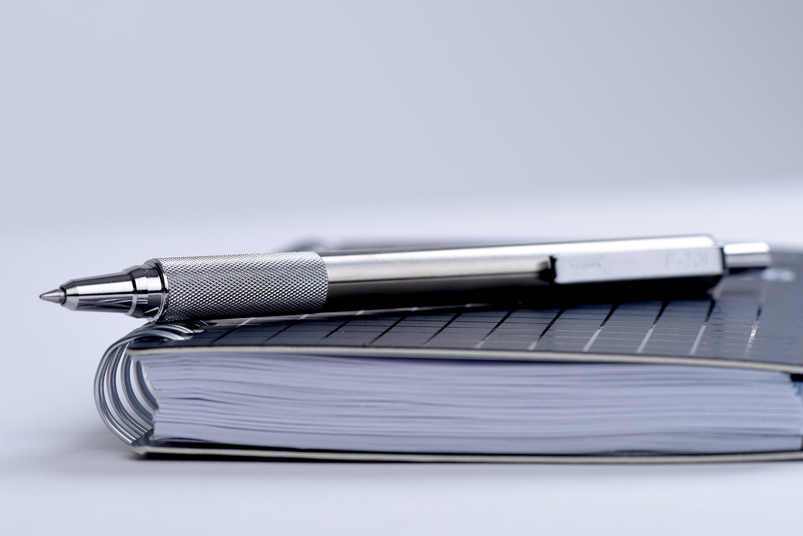 Zebra Pen F-701 comparación de tamaño junto a una libreta para apreciar escala